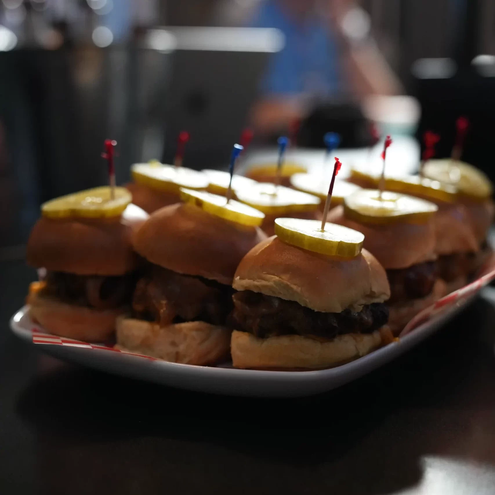 twelve burger sliders on an appetizer plate for a large group to share
